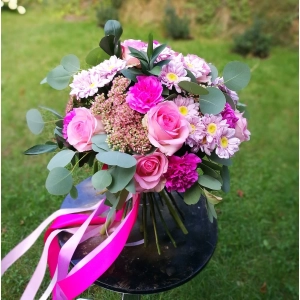 Różowy bukiet kwiatów ze wstążkami.